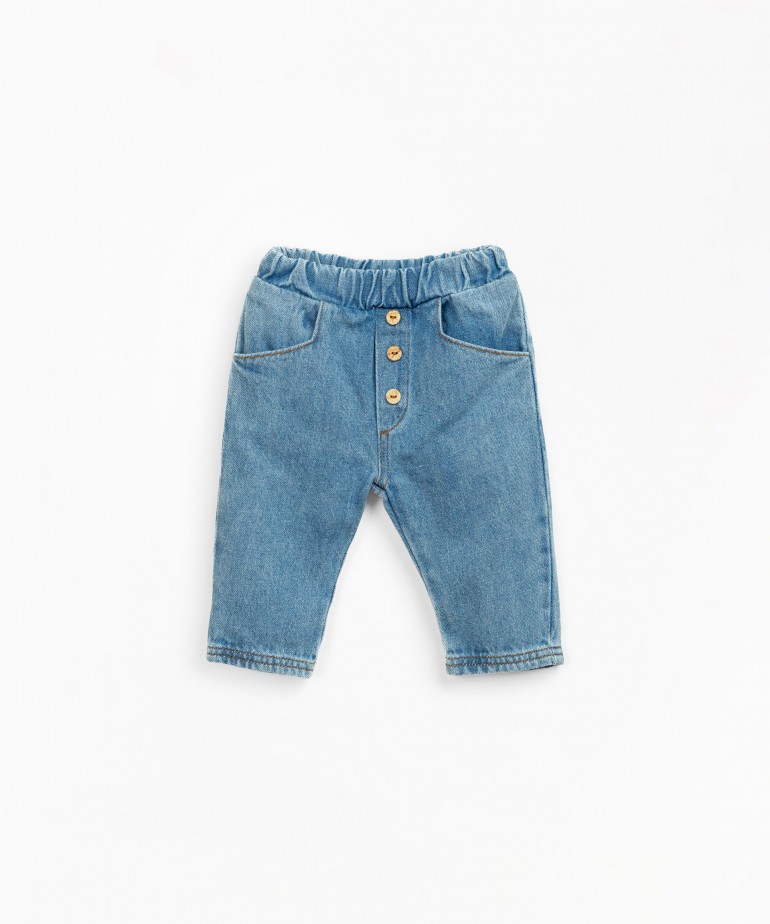 Denim trousers with decorative coconut buttons and pockets