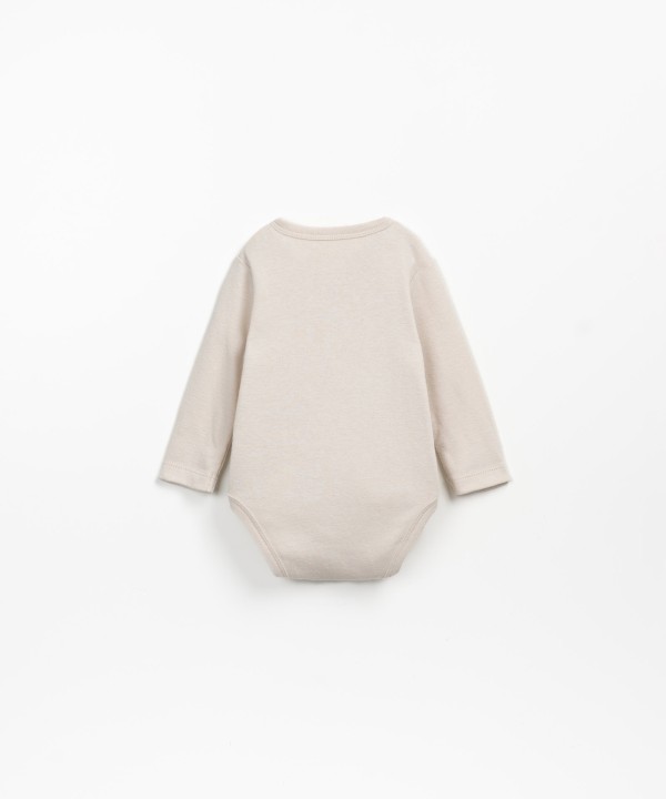 Double-breasted bodysuit in a mixture of organic cotton and recycled cotton.