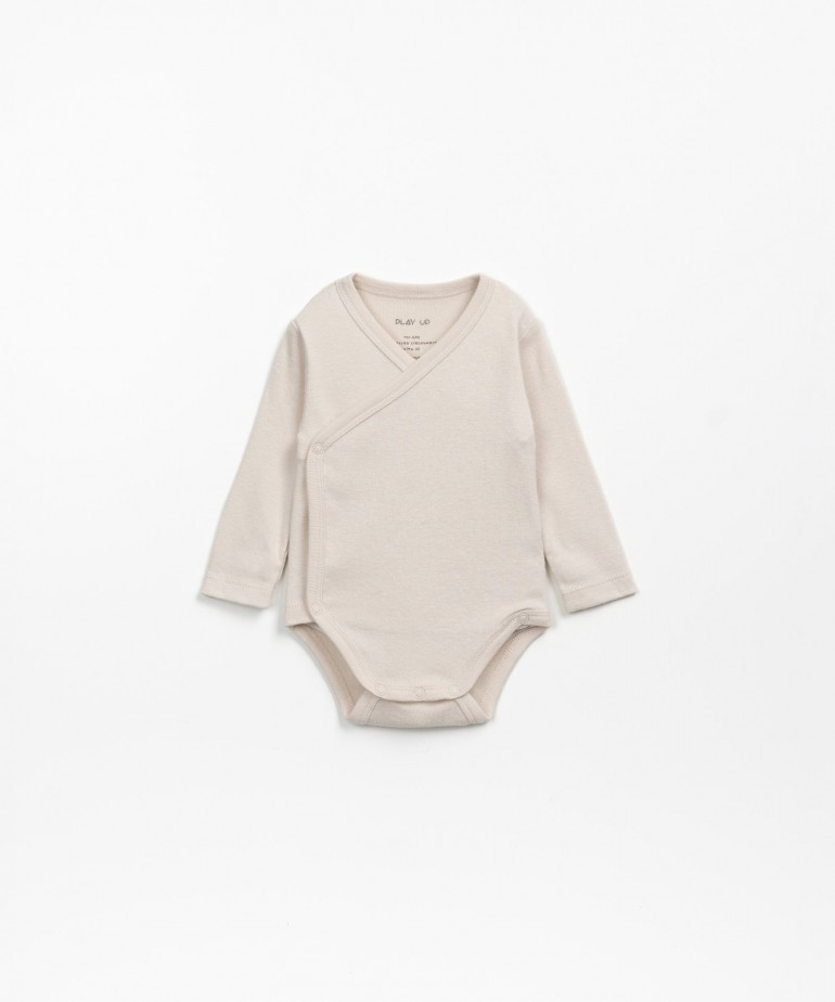 Double-breasted bodysuit in a mixture of organic cotton and recycled cotton.