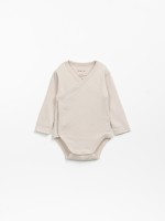 Double-breasted bodysuit in a mixture of organic cotton and recycled cotton.
