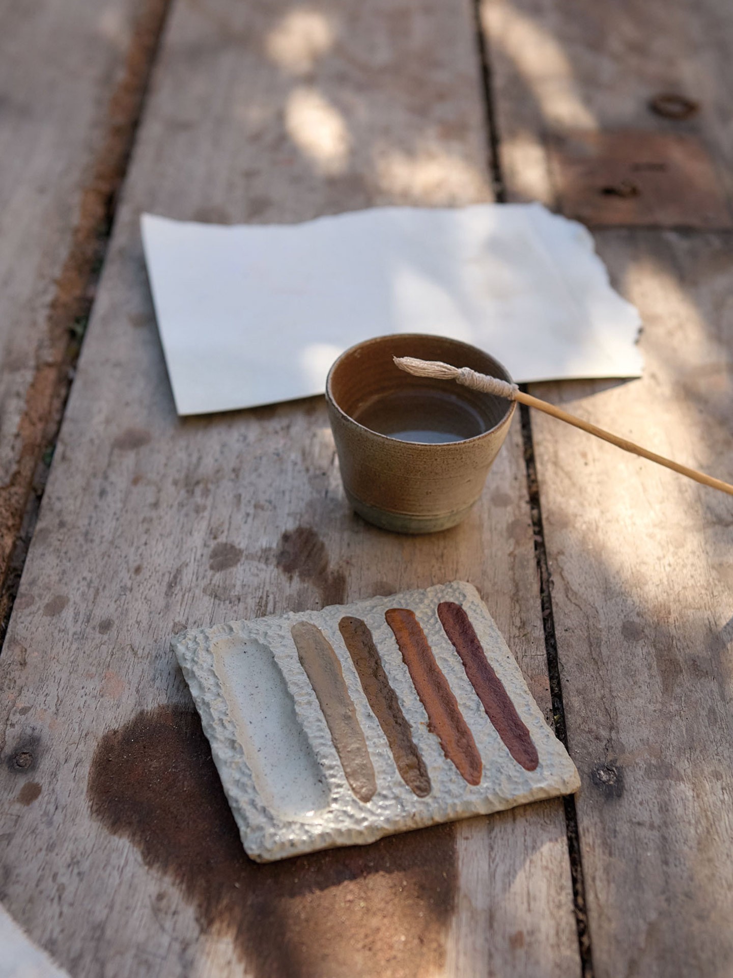 Paleta em cerâmica com pincel de algodão e aguarelas